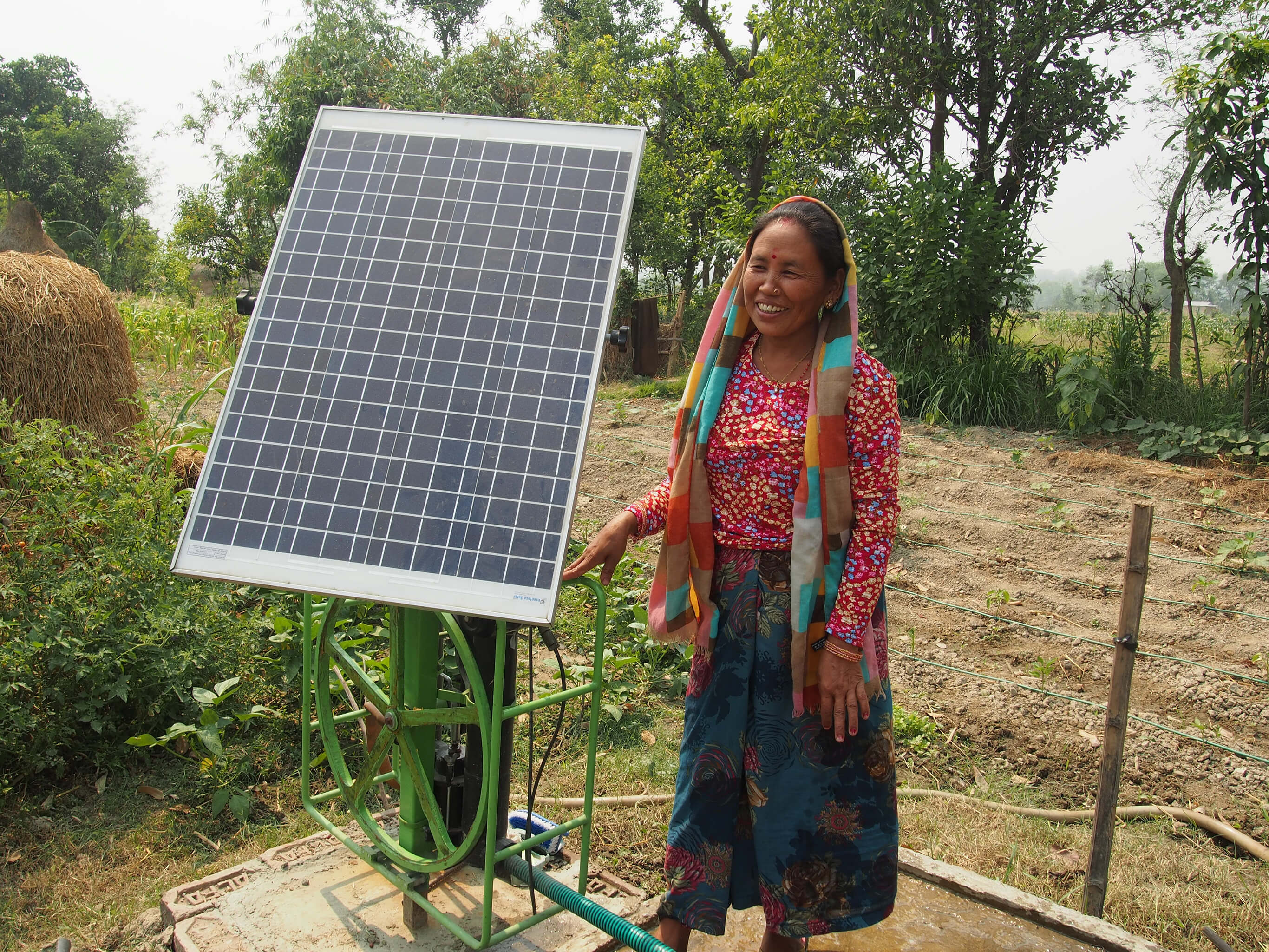 woman standing next to a solar panel in Nepal